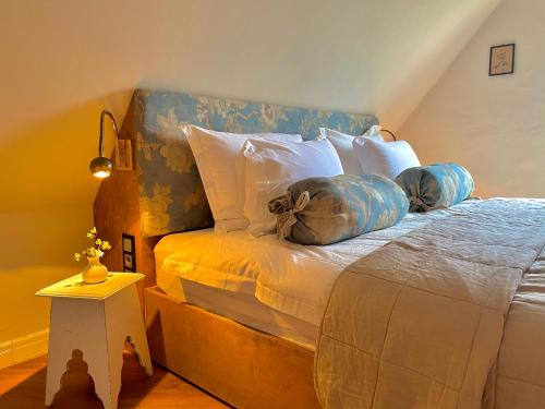 Schlafzimmer mit einem Bett mit blauen und weißen Kissen in der Unterkunft Weisst Du noch - Gästehäuser & Suiten Rügen in Seedorf