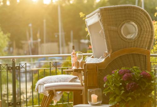 einen Korbstuhl auf dem Balkon in der Unterkunft Weisst Du noch - Gästehäuser & Suiten Rügen in Seedorf