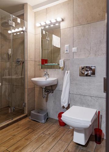 a bathroom with a toilet and a sink and a shower at Leśne Patio in Katowice