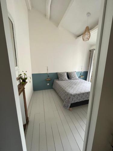 a bedroom with a bed in a white room at Le 19 Rue **,Maison de charme proche du Puy du Fou in Mouchamps