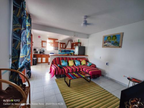 un soggiorno con divano rosso e una cucina di Luketo a Vieux-Habitants