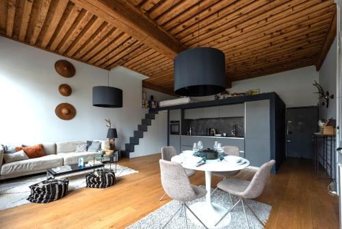 un salon avec une table et des chaises blanches dans l'établissement LE LOFT ETHNIC - avec jolie vue sur la Saône, à Lyon