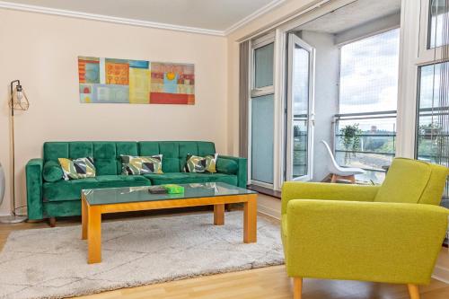 a living room with a green couch and two chairs at Oakdale Apartments in Woking