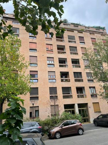 a large brick building with cars parked in front of it at Claudia's Home in FieraCity&MiCo&SanSiro in Milan