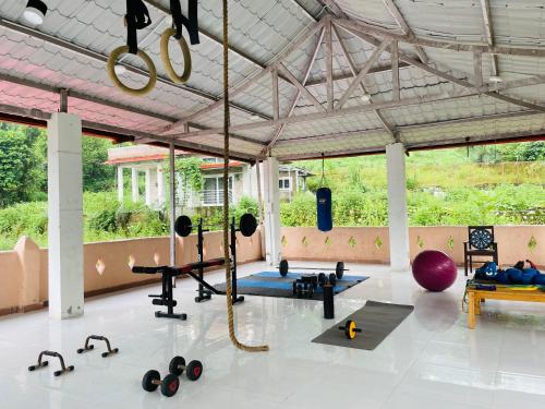 un gimnasio con un montón de equipamiento en una habitación en Shiv Shakti Yogpeeth Cottages en Rishīkesh