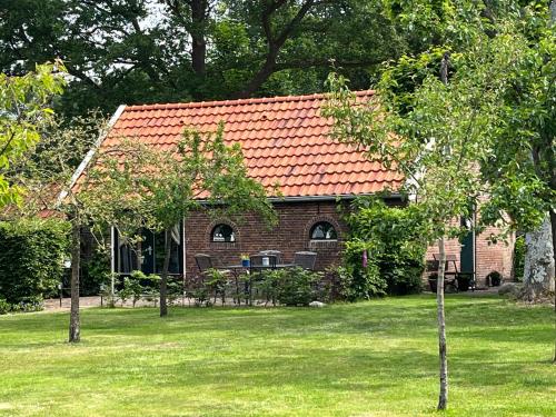 a small brick house with a red roof at Landelijk gelegen Huisje op erf in Veeningen