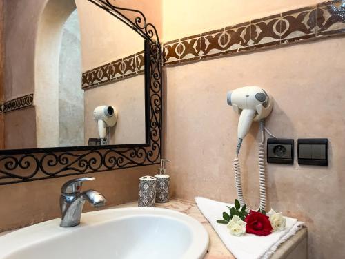 a bathroom with a sink and a blow dryer at Riad Pacha Palace in Fès