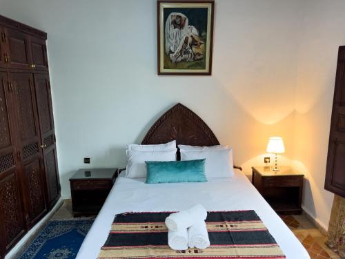 a bedroom with a bed with two towels on it at Riad Pacha Palace in Fès