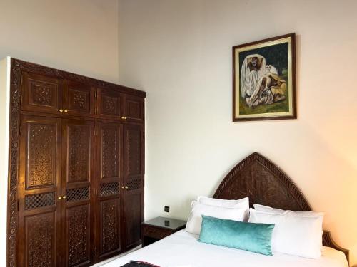 a bedroom with a bed and a painting on the wall at Riad Pacha Palace in Fès