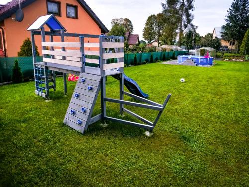 a playground with a slide in a yard at Szary Domek w Karkonoszach in Podgórzyn