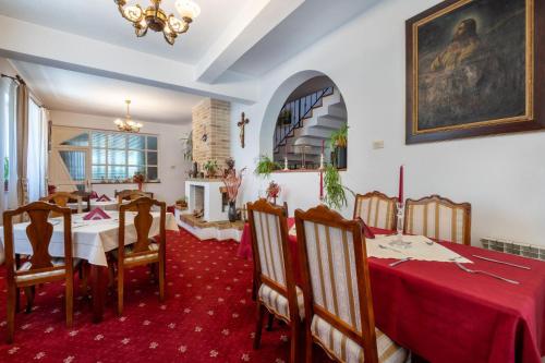 a dining room with two tables and a red carpet at Villa-Hotel Escala in Cluj-Napoca