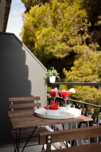 a table with two glasses of wine on a balcony at Hotel Sitges in Sitges