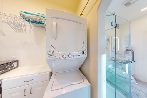 a bathroom with a washer and dryer next to a shower at Cottam Pines B in Taos