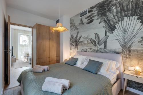 una camera da letto con un grande letto con asciugamani di Loulou Apartman - Balatonboglár a Balatonboglár