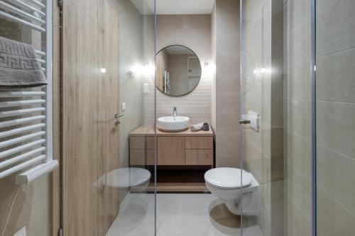 a bathroom with a toilet and a sink and a mirror at Loulou Apartman - Balatonboglár in Balatonboglár