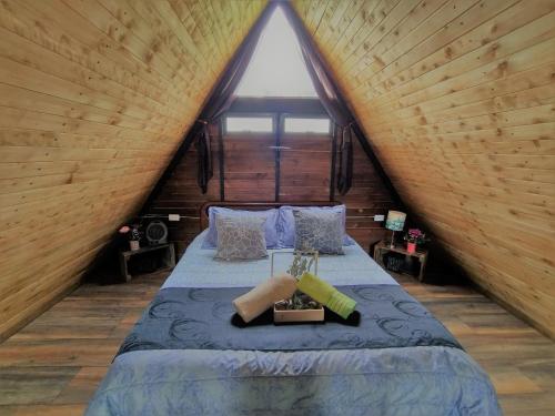 una camera con un letto in una baita di tronchi di EUCALYPTO CHALET a Guarne