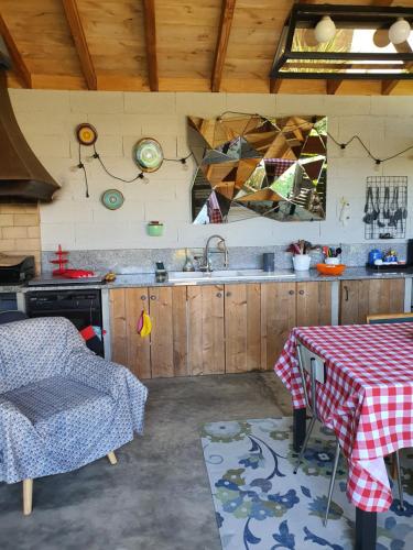 a kitchen with a sink and a table with a table cloth at A l'Ecole Buissonnière, chambre d'hôtes en Sidobre in Lacrouzette