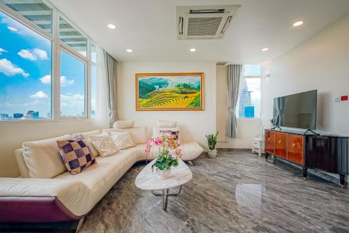 uma sala de estar com um sofá e uma televisão de ecrã plano em The One Sai Gon em Ho Chi Minh