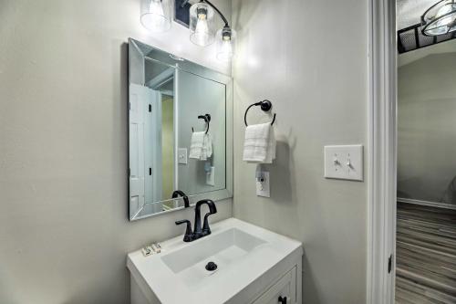 a white bathroom with a sink and a mirror at Jacksonville Retreat with Yard about 16 Mi to Beach in Jacksonville
