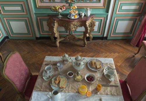 einen Tisch mit Teller Essen auf einem Zimmer in der Unterkunft Chateau du Hallay in Montaigu-Vendée
