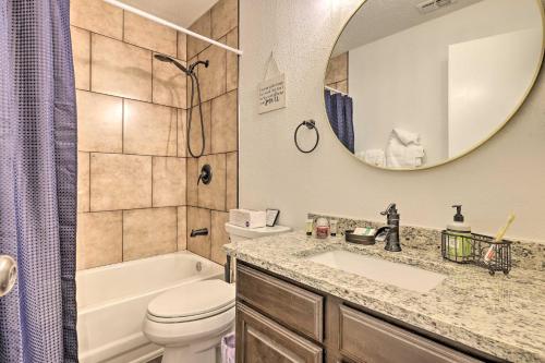 a bathroom with a sink and a toilet and a mirror at San Antonio Family Home with Game Room and Fire Pit! in San Antonio