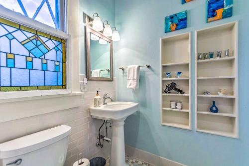 a bathroom with a sink and a toilet and a window at Colorful Cottage with Deck about 5 Mi to Downtown! in Little Rock