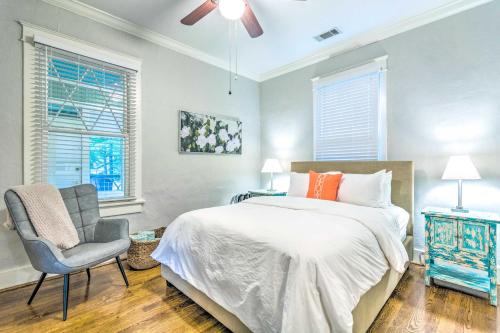 a bedroom with a bed and a chair and windows at Colorful Cottage with Deck about 5 Mi to Downtown! in Little Rock