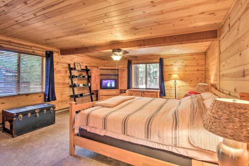 een slaapkamer met een bed in een blokhut bij Relax and Play in the Pines Cabin with Deck! in Pinetop-Lakeside