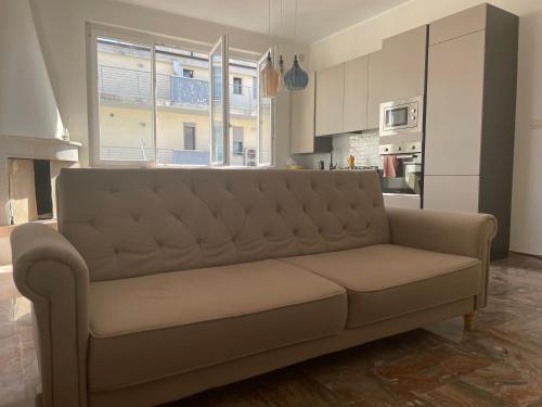 a couch in a living room with a kitchen at Casa al Mare Pescara in Pescara