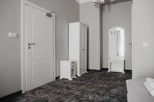a room with two doors and a bed and a mirror at Pałac Lacon in Kazimierza Wielka