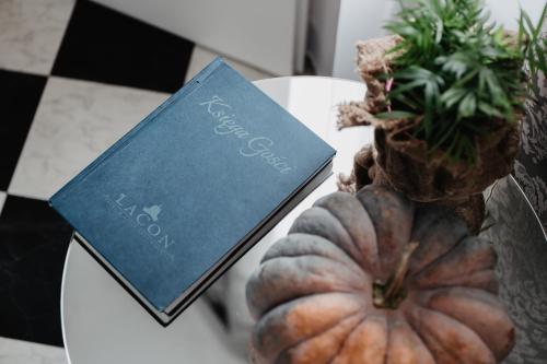 a table with a pumpkin and a book on it at Pałac Lacon in Kazimierza Wielka