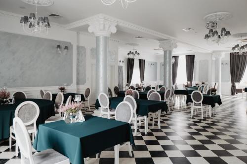 a restaurant with black and white checkered floor and tables and chairs at Pałac Lacon in Kazimierza Wielka