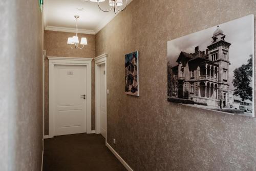 a hallway with two pictures of a house on the wall at Pałac Lacon in Kazimierza Wielka