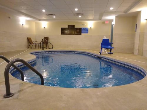 una gran piscina en una habitación con una silla azul en Comfort Inn & Suites Brattleboro I-91, en Brattleboro
