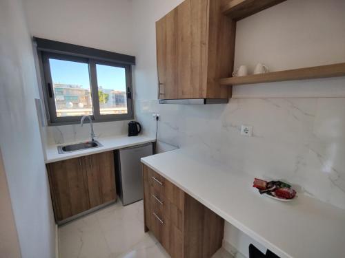 a kitchen with a counter and a sink and a window at Finikas Suites & Apartments Airport By Airstay in Artemida