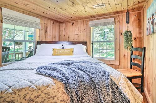 Cama en habitación con paredes y ventanas de madera en The Creek Winfield Gem 73 Acres of Privacy, 