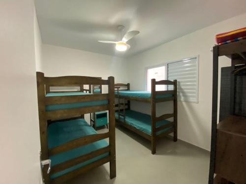 a room with three bunk beds and a window at Casa em Bertioga condomínio 250 metros da praia in Bertioga