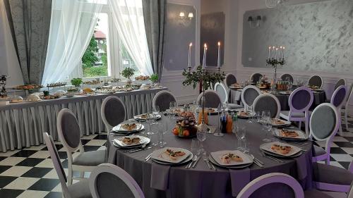 a dining room with a long table and chairs at Pałac Lacon in Kazimierza Wielka