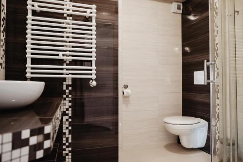 a bathroom with a white toilet and a sink at Pałac Lacon in Kazimierza Wielka