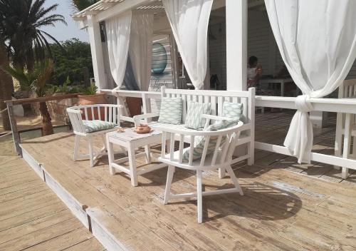 a porch with two white chairs and a table at Sea view house, Praia de Chaves, Boa Vista, Cape Verde, FREE WI-FI in Cabeçadas