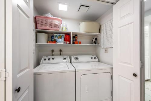 a white laundry room with a washer and dryer at Sunshine On My Shoulders Permit# STR2022-0160 in Palm Desert