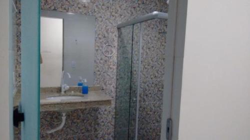 a bathroom with a shower and a sink and a mirror at recanto da paz in Una