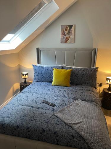 1 dormitorio con 1 cama con almohadas azules y amarillas en St Elmos Townhouse en Derry