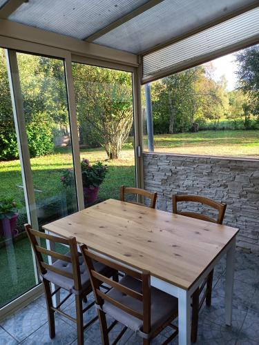 - une table et des chaises en bois sur une terrasse couverte dans l'établissement Entre Puy-de-Dôme et Corrèze Appartement pour 4 personnes avec terrasse et jardin, à Monestier-Merlines