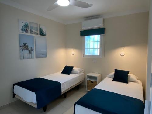 a bedroom with two beds and a window at Bungalows Granada Beach in Playa del Ingles