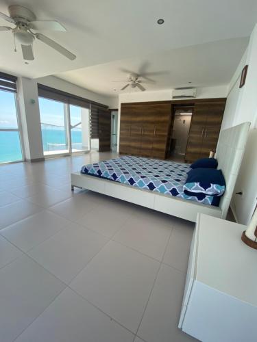 a large bedroom with a bed with blue pillows at Departamentos frente al mar en Resort Playa Azul-Tonsupa in Tonsupa