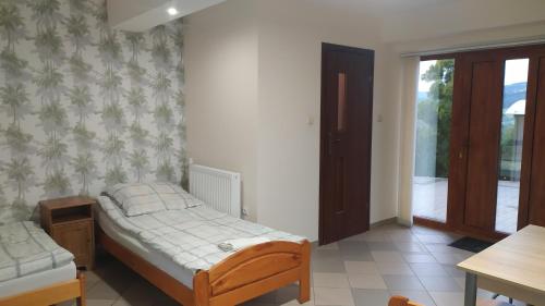 a bedroom with two beds and a sliding glass door at Agrorelax - Kasina Wielka in Kasina Wielka