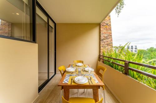 a dining room with a table and chairs on a balcony at Syrena Adventure in Playa del Carmen