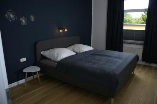 a bed in a bedroom with a blue wall at APARTMENT SONNE Reusa in Plauen