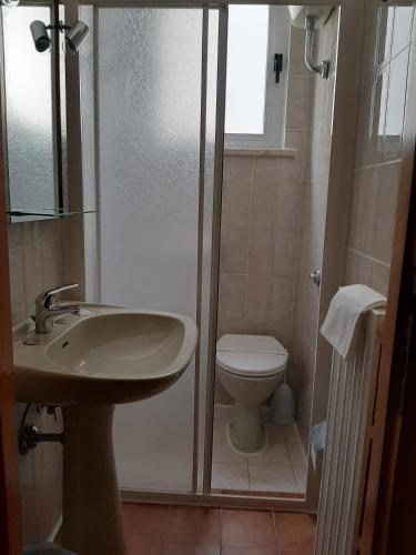 a bathroom with a shower and a sink and a toilet at Hotel Cucciolo in Donoratico